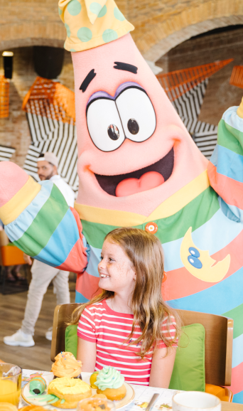A Little Girl Sitting At A Table With A Birthday Cake